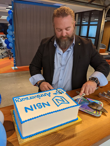 NSIN Acting Director, Greg Bernard, cuts the NSIN anniversary cake.